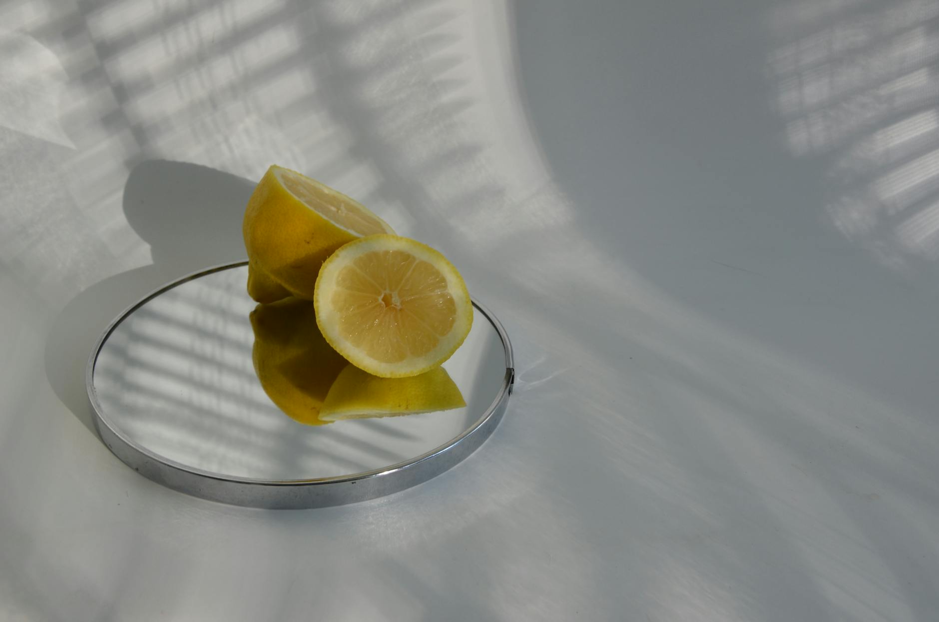 Citrons frais tranchés sur un miroir avec des ombres nettes, illustrant la variabilité et la fraîcheur