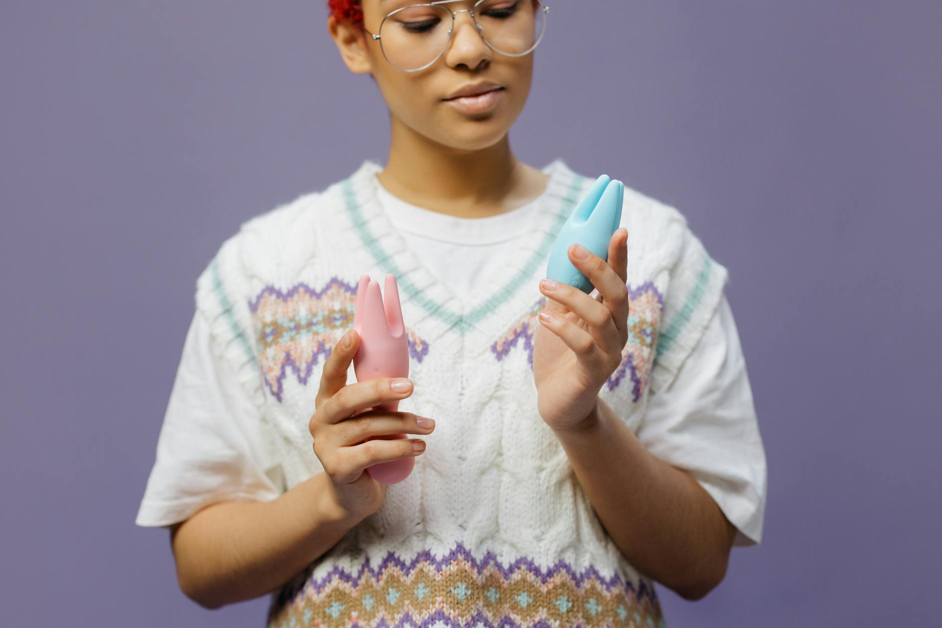Frau mit Brille hält einen Lem Vibrator mit blauem und rosa Design nachdenklich