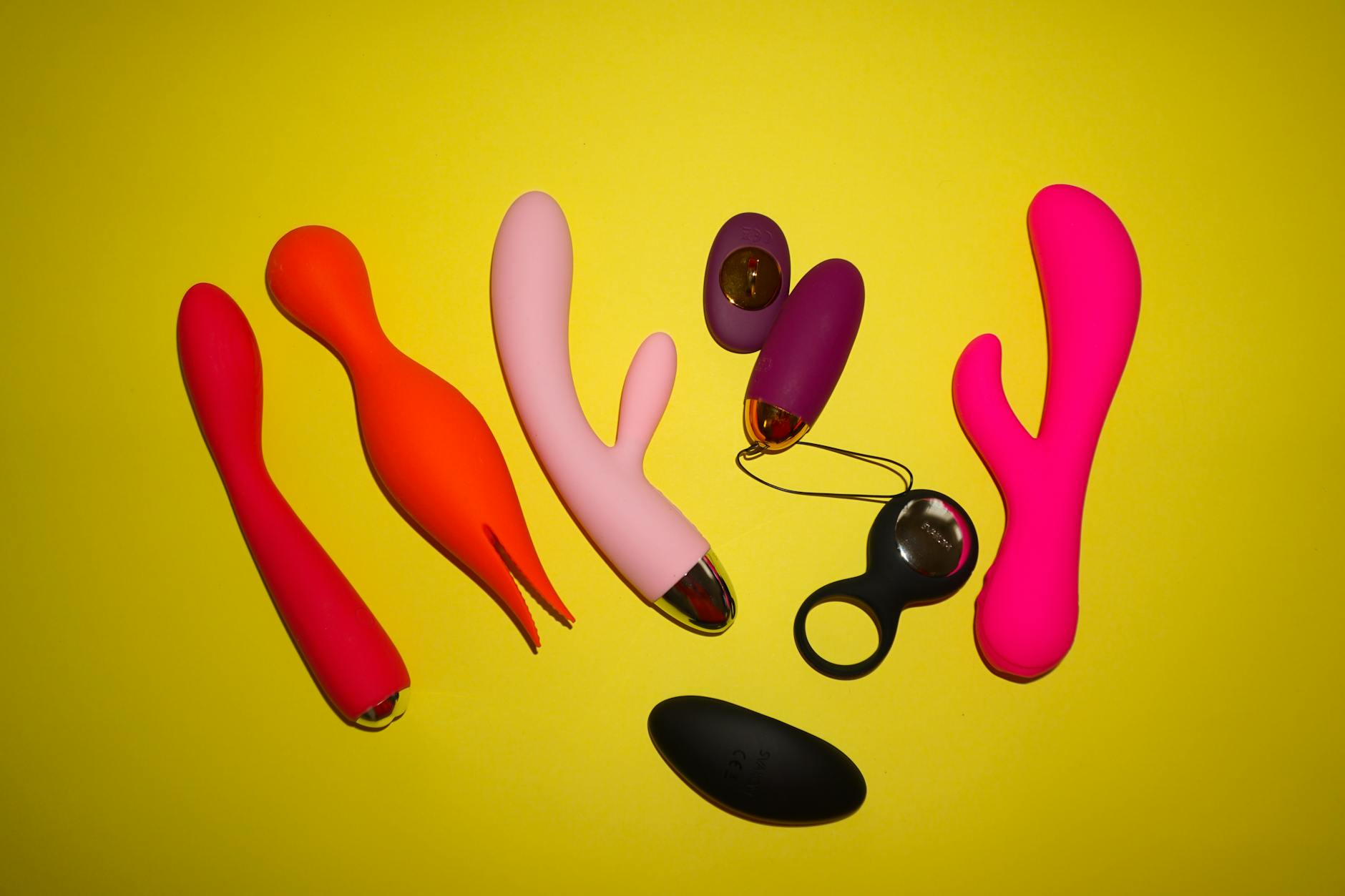 Nahaufnahme von Händen, die einen blauen Vibrator gegen violetten Hintergrund halten, Symbol für moderne weibliche Selbstliebe