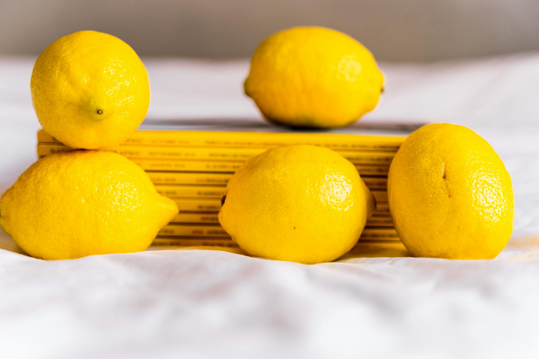 Citrons frais entassés avec des livres sur une nappe blanche, symbole de renouveau et d'exploration